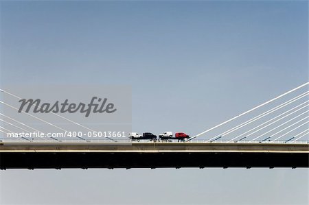 Truck with cars crossing a bridge