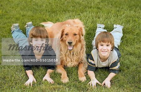 Boys Laying down With Golden Retriever