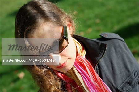 Fashionable business woman with dark glasses and colorful scarf.