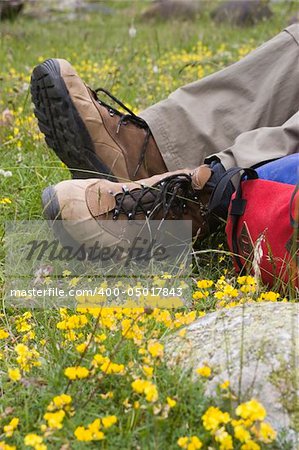 Boots of a mountaineer and rucksack on a meadow - focus on the boots.
