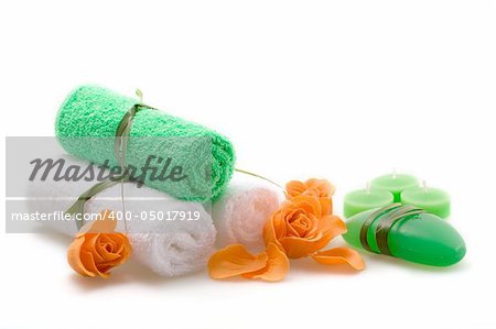 Spa concept of green color: the towel, soap and candles over white background