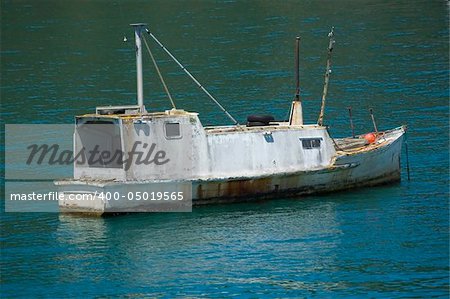 Old grunge rusty motor boat on the green water