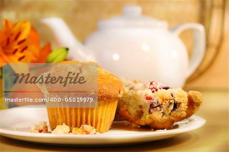 Breakfast with cranberry muffins, teapot and orange juice on bamboo mat