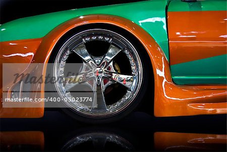 orange and green tuning car, isolated over black mirror