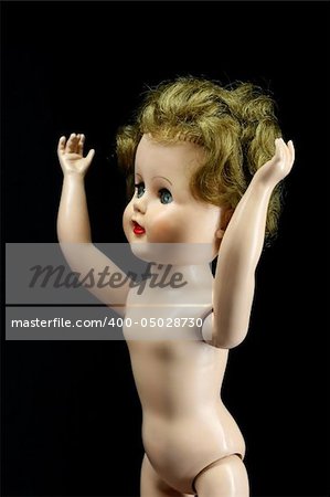 An old worn doll with arms reaching up