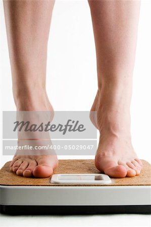 A pair of female feet standing on tip toe on a bathroom scale