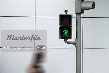 People crossing the road in motion effect with the green safe signal.