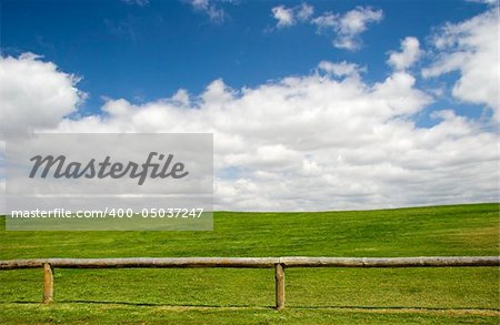 Beautiful meadow with a great blue sky and wooden fence