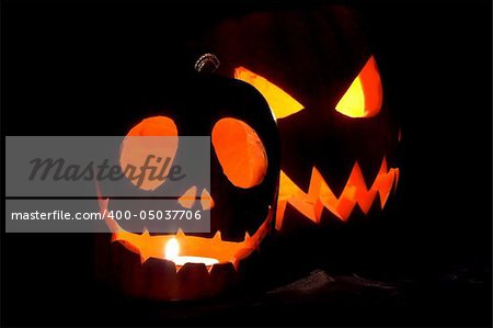 Jack-o-lanterns, two Halloween pumpkins glowing in the night