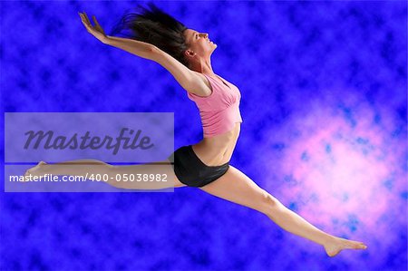 a cute gymnast in a hard jump on a blue background