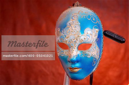 carnival mask on a support, close-up, red background