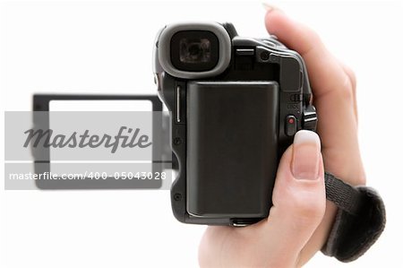 Woman holding a small camcorder. Shallow depth of field. Focus on the back of the camera. Isolated on a white background.