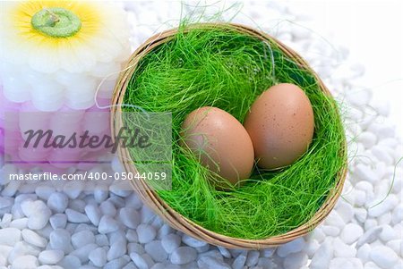 Easter eggs in a basket and green straw