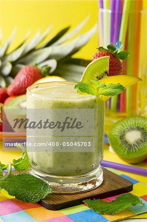 A glass of kiwi smoothie garnished with fresh fruits