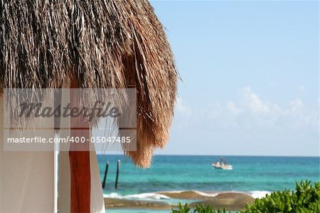 A palm hut with the beautiful Carribean sea in the background.