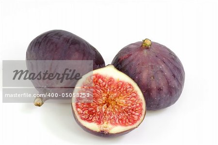 Two and a half ripe figs on bright background
