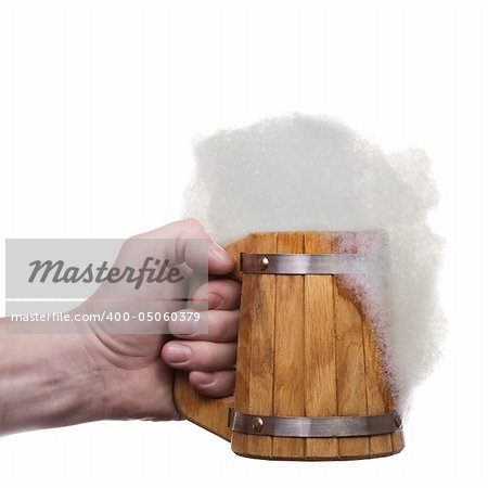 The man's hand holds big wooden beer mug collected from plates with froth. Isolated on white [with clipping path].