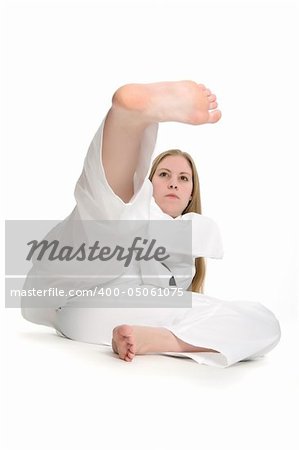 Black belt female martial artist doing kick on the ground.