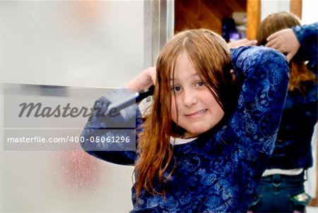 A young girl trying to get the tangles out of her hair