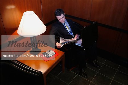 Businessman waiting in an office lobby with his briefcase open