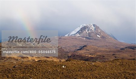 Sunshine creates a rainbow in a Scottish mountain landscape