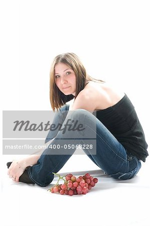 Beautiful young woman with red grape. Isolated