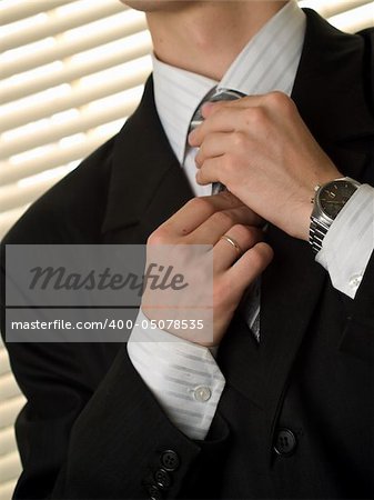 Young married businessman ties necktie diagonal orientation