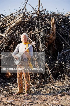 Barefoot banjo Player in Front of a Big Pile of Wood