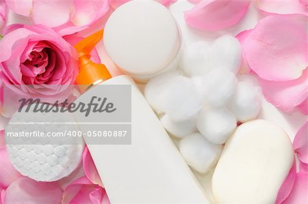 Skin care products with rose petals and cotton swabs