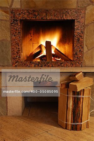 Fireplace. Flaring fire in a fireplace the reveted wild stone and a marble