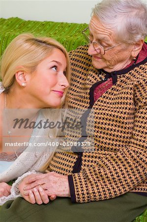 A young woman  together whit an older one talking, smiling at her - part of a series.