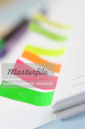 A book with colorful sticker notes. Very shallow depth of field. focus on green tag.