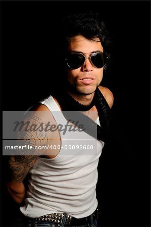 Portrait of young male fashion model with arm tattoo and sunglasses