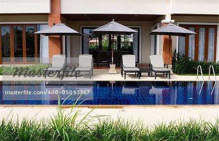 Swimming pool with deck chairs and umbrellas.
