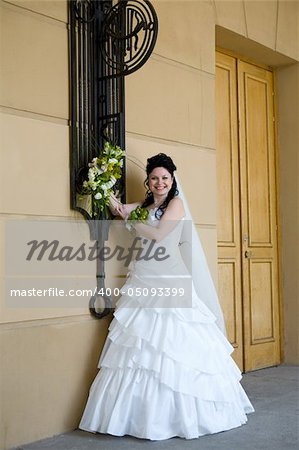 beautiful bride standing near the wall