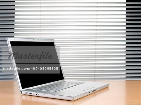 A laptop on a table at a modern office.