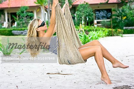 Girl sitting in hammock on the beach