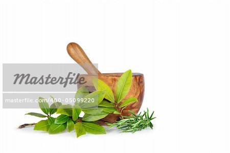 Rosemary and bay leaf herb sprigs with an olive wood pestle and mortar over white background.