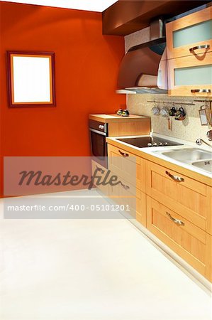 Contemporary kitchen in light wood with terracotta walls