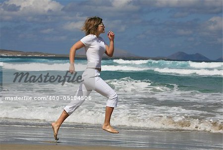 Running woman on the beach