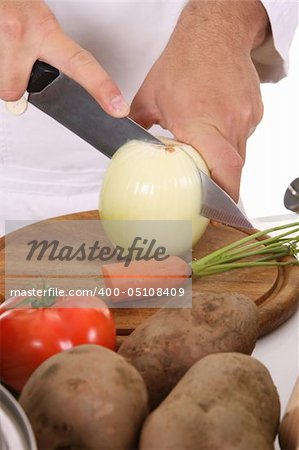 chef preparing lunch and cutting onion with knife