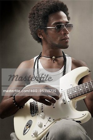 Portrait of young african man playing electric guitar