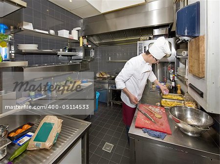 A chef in a profesional kitchen, preparing dinner