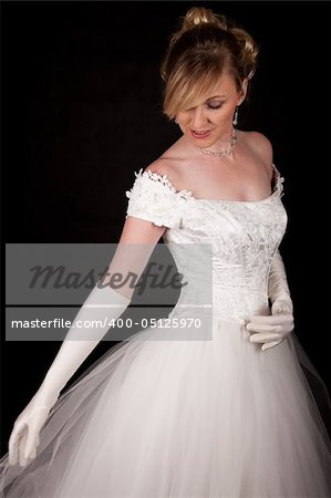 Attractive blond woman wearing white wedding gown with wide flowing skirt over black