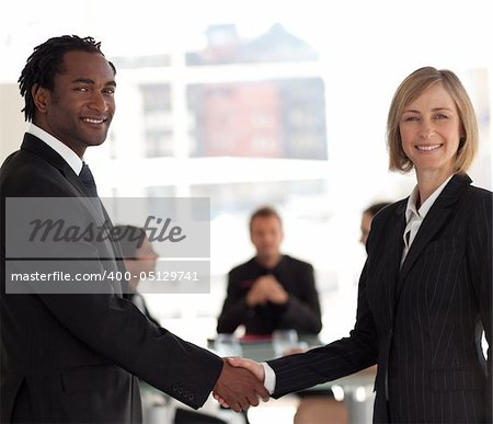 Friendly Business handshake in front of workgroup