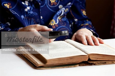 An elderly woman reading a very old book