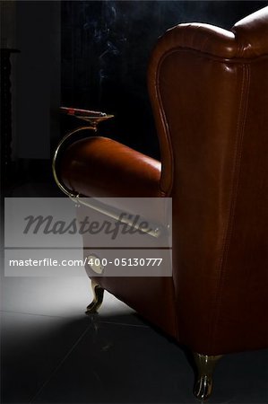 Cigar and beautiful leather armchair on marble to a floor