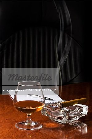 Snifter glass of cognac and cigar