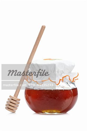 Honey jar and wooden drizzler, reflected on white background