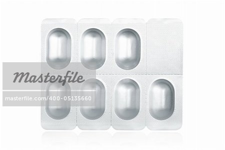 Blister pack containing medical pills reflected on white background